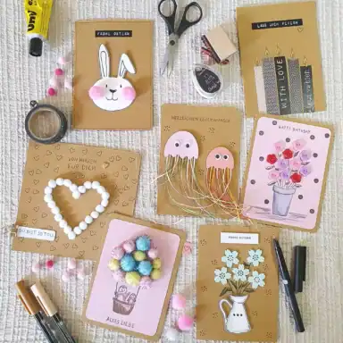 Kreative Glückwunschkarten mit bunten Designs und Bastelmaterialien für den Karten-Workshop.